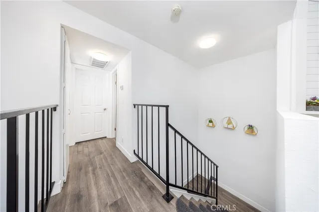 a view of a hallway with wooden floor and staircase