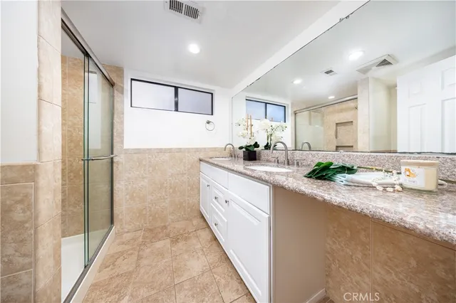 a large bathroom with a granite countertop sink mirror and a shower