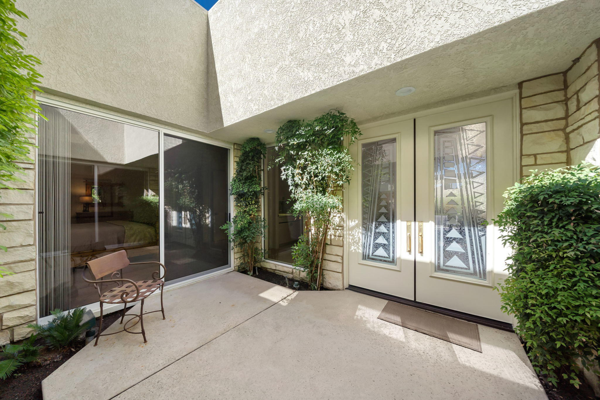74 Mayfair Drive Rancho Mirage, CA 92270 - Photo 35 of 35 a view of an entryway with a floor to ceiling window and potted plants
