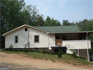 a view of a house with a yard chairs and a yard