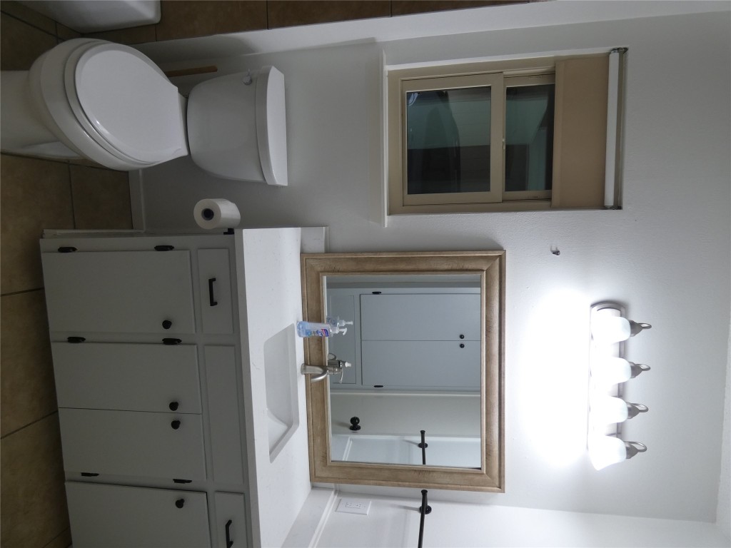 2203 Western Trails Boulevard, Unit B Austin, TX 78745 - Photo 16 of 33 a bathroom with a toilet sink and mirror