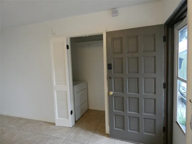 a view of an empty room with cabinet and entryway