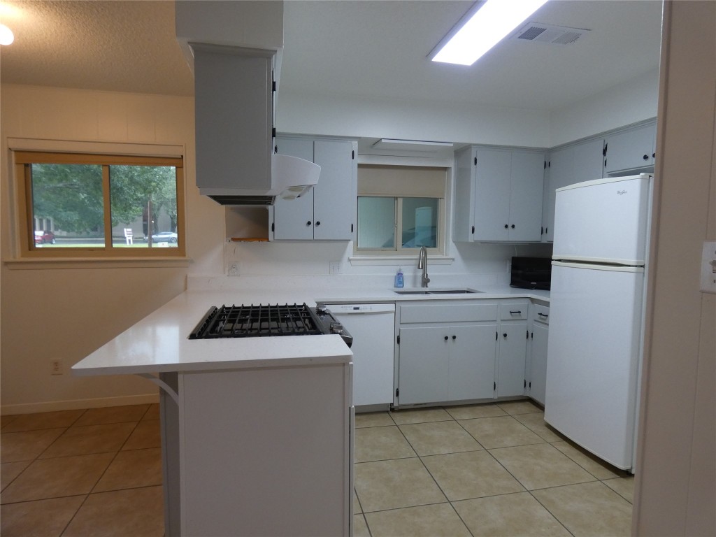 2203 Western Trails Boulevard, Unit B Austin, TX 78745 - Photo 5 of 33 a kitchen with a sink stove and refrigerator
