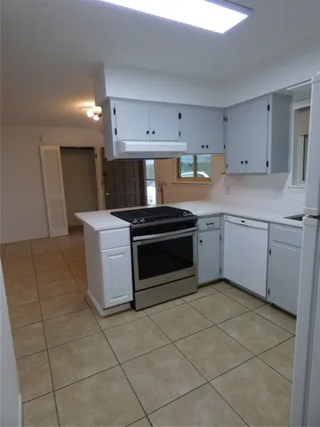a kitchen with a stove sink and cabinets