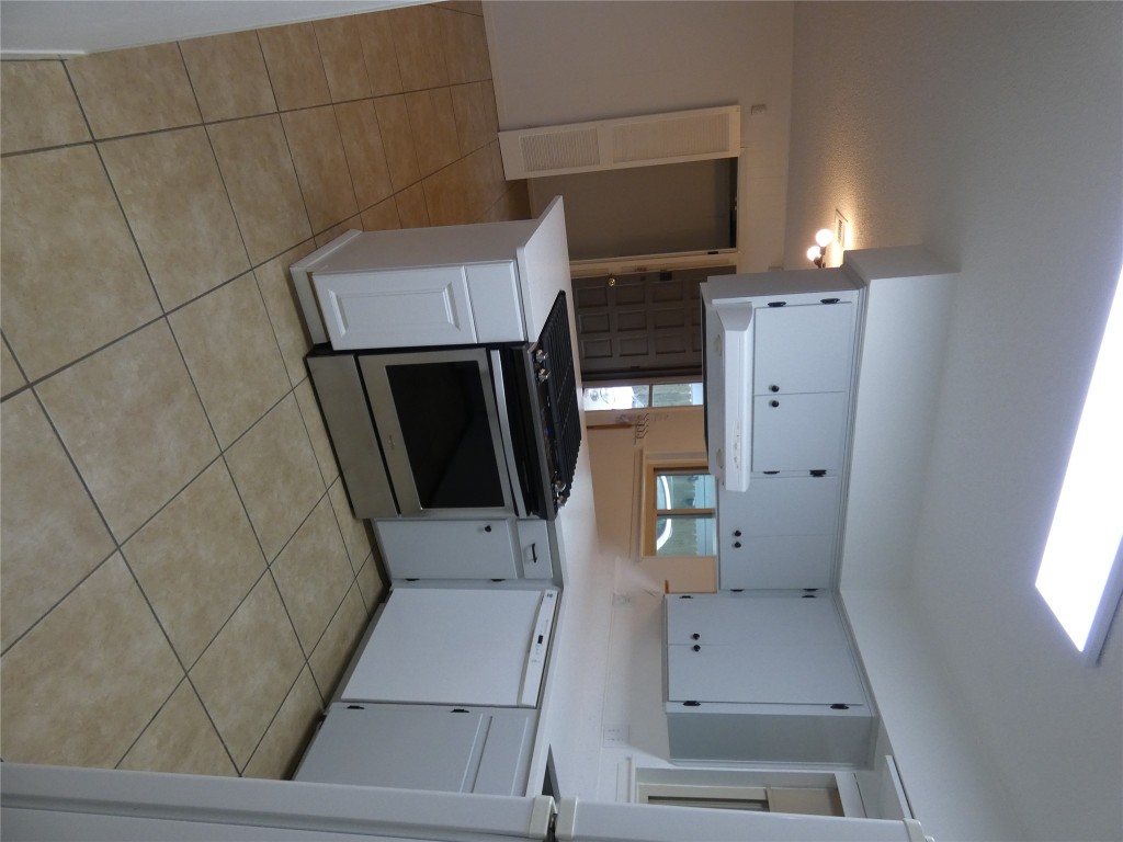 2203 Western Trails Boulevard, Unit B Austin, TX 78745 - Photo 7 of 33 a kitchen with a stove sink and cabinets
