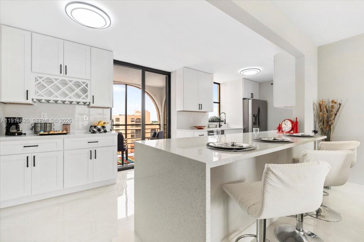 a kitchen with white cabinets and sink