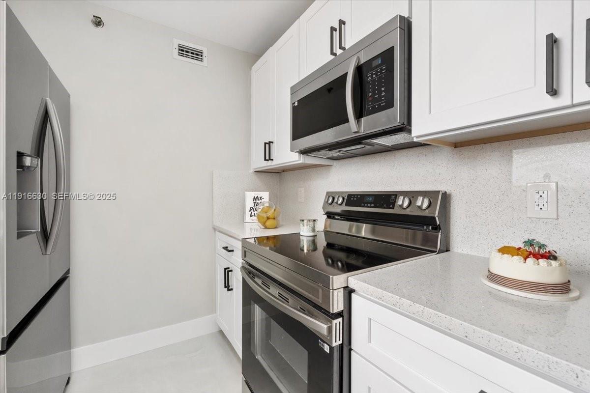 7129 Promenade Drive, Unit 801 Boca Raton, FL 33433 - Photo 13 of 42 a kitchen with cabinets and steel stainless steel appliances
