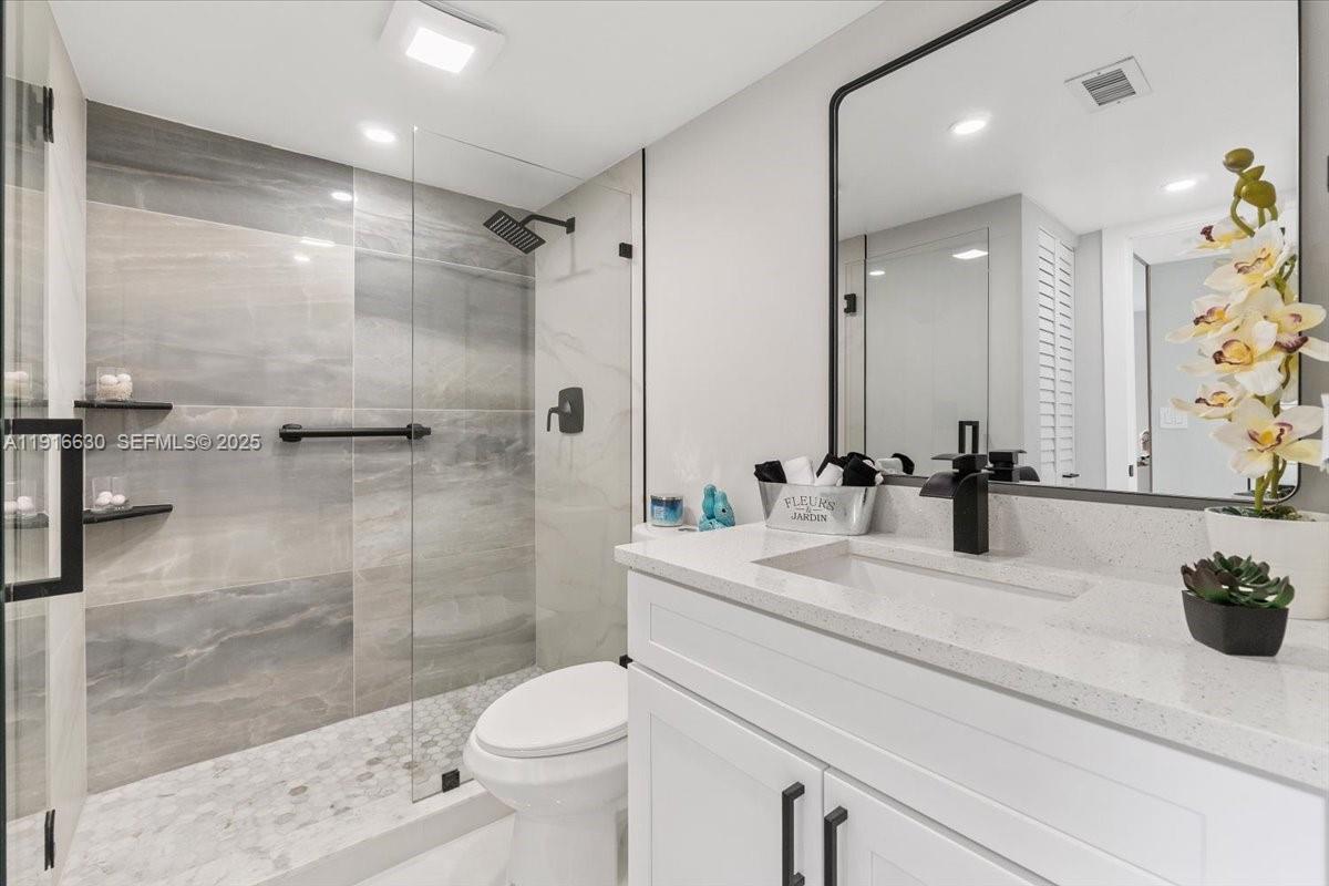 7129 Promenade Drive, Unit 801 Boca Raton, FL 33433 - Photo 28 of 42 a bathroom with a sink a toilet and shower