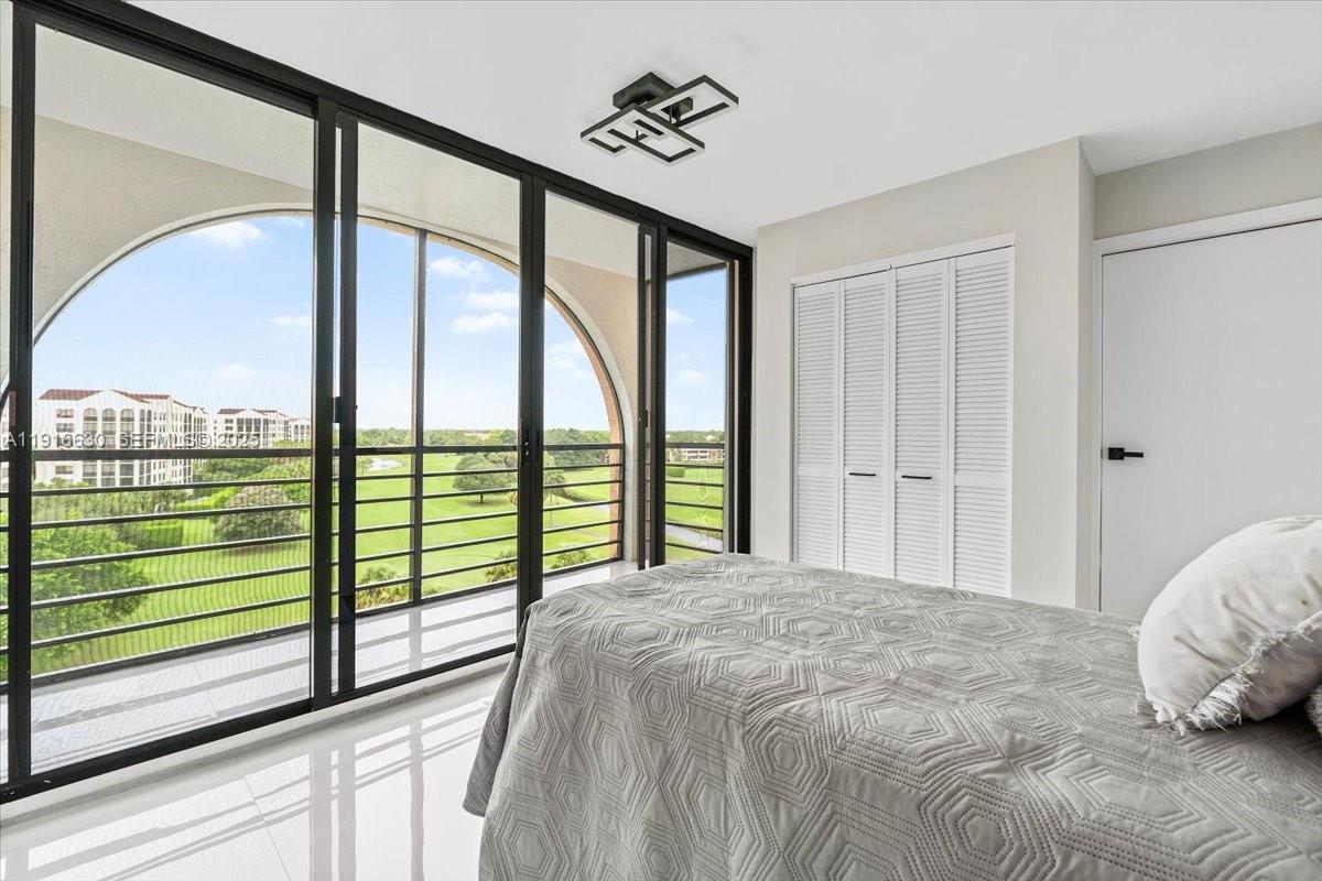 7129 Promenade Drive, Unit 801 Boca Raton, FL 33433 - Photo 32 of 42 a bedroom with a large window and a bed