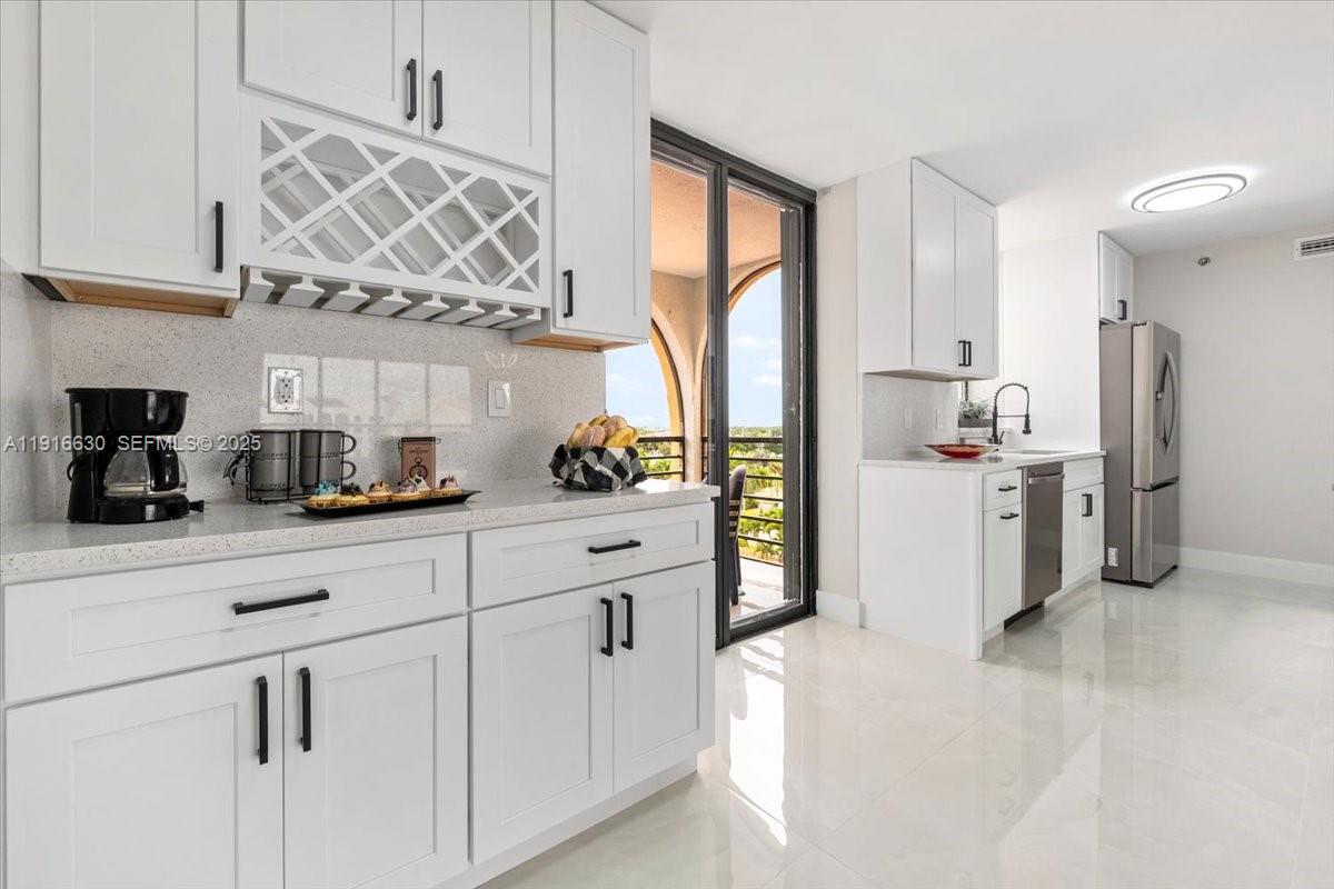 7129 Promenade Drive, Unit 801 Boca Raton, FL 33433 - Photo 10 of 42 a kitchen with a refrigerator and cabinets