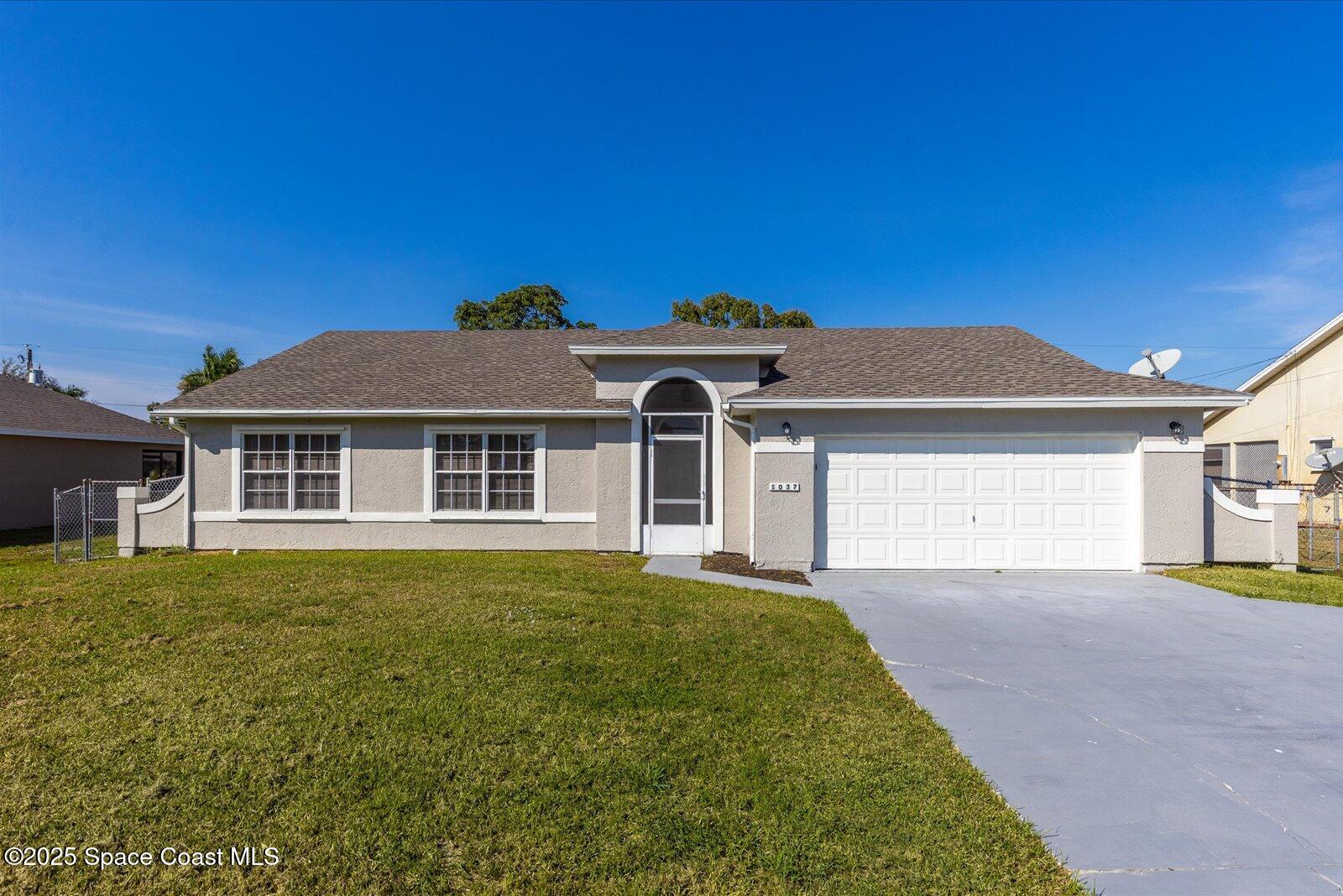 1037 Southwest California Boulevard Port St. Lucie, FL 34953 - Photo 1 of 38 a front view of a house with a garden and yard