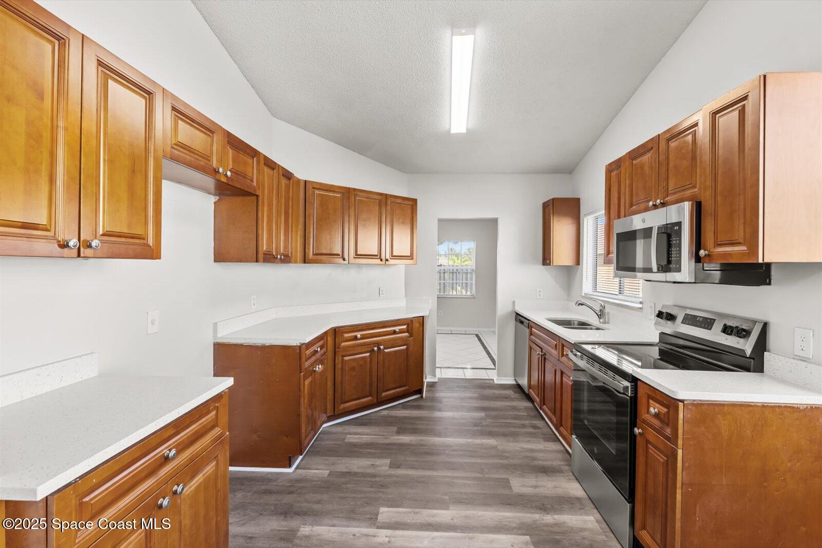 1037 Southwest California Boulevard Port St. Lucie, FL 34953 - Photo 12 of 38 a large kitchen with stainless steel appliances granite countertop a stove a sink dishwasher a microwave oven with granite countertops and cabinets