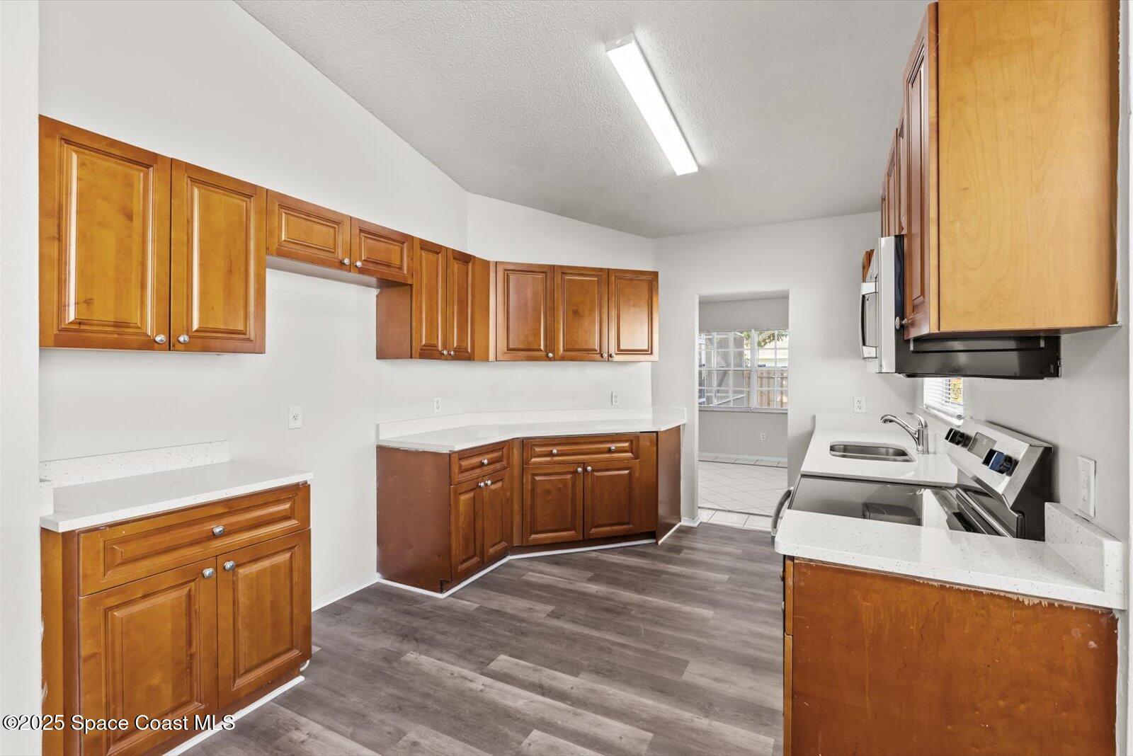 1037 Southwest California Boulevard Port St. Lucie, FL 34953 - Photo 13 of 38 a kitchen with stainless steel appliances granite countertop a sink stove and cabinets