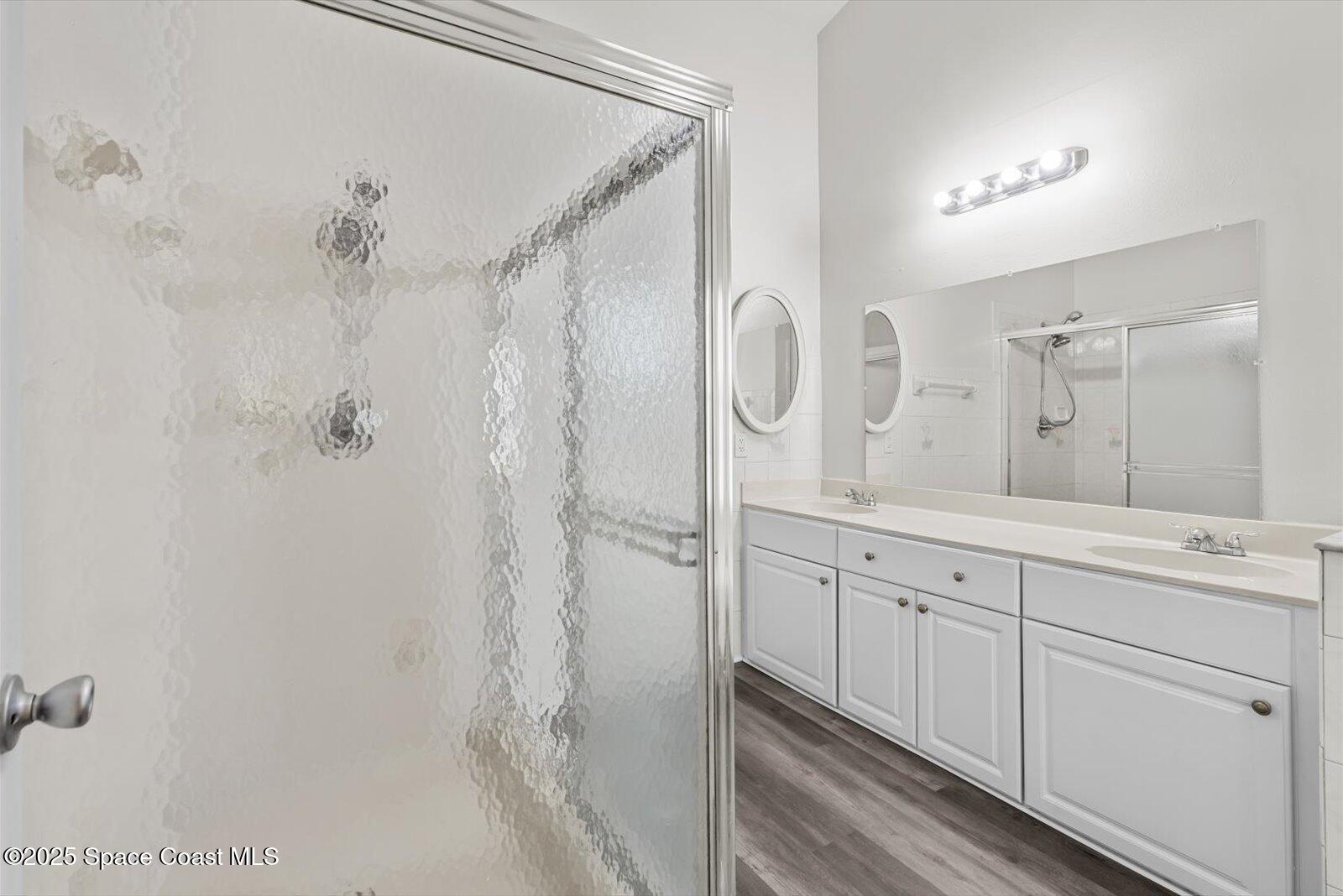 1037 Southwest California Boulevard Port St. Lucie, FL 34953 - Photo 17 of 38 a spacious bathroom with a double vanity sink a mirror a shower and vanity