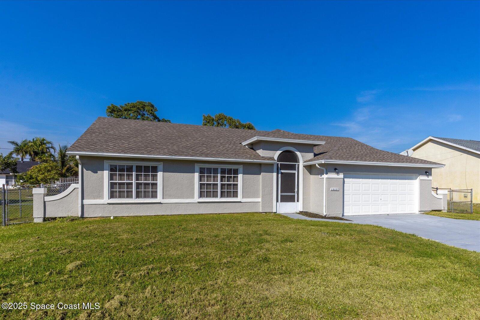 1037 Southwest California Boulevard Port St. Lucie, FL 34953 - Photo 2 of 38 a front view of a house with a garden