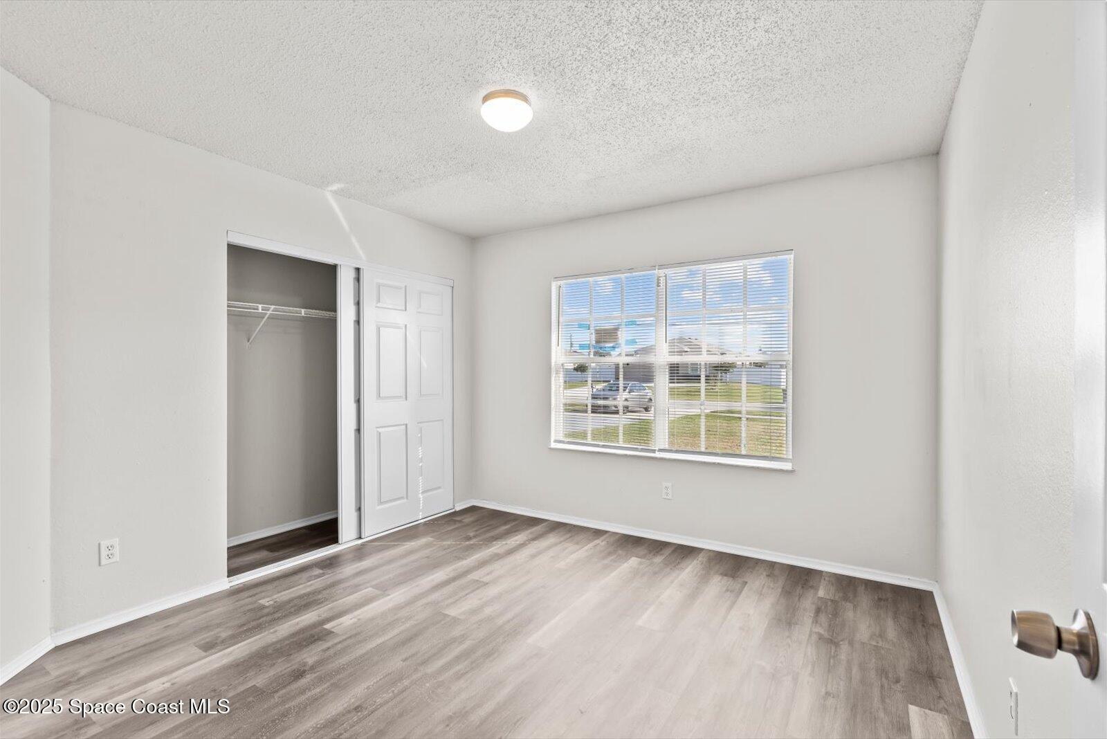 1037 Southwest California Boulevard Port St. Lucie, FL 34953 - Photo 22 of 38 an empty room with wooden floor and windows