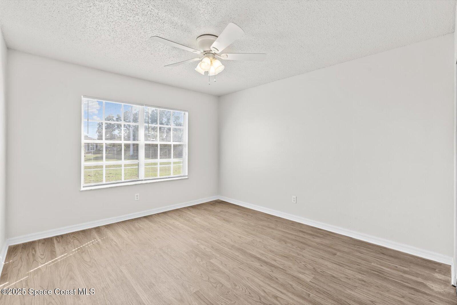 1037 Southwest California Boulevard Port St. Lucie, FL 34953 - Photo 25 of 38 a view of an empty room with wooden floor and a window