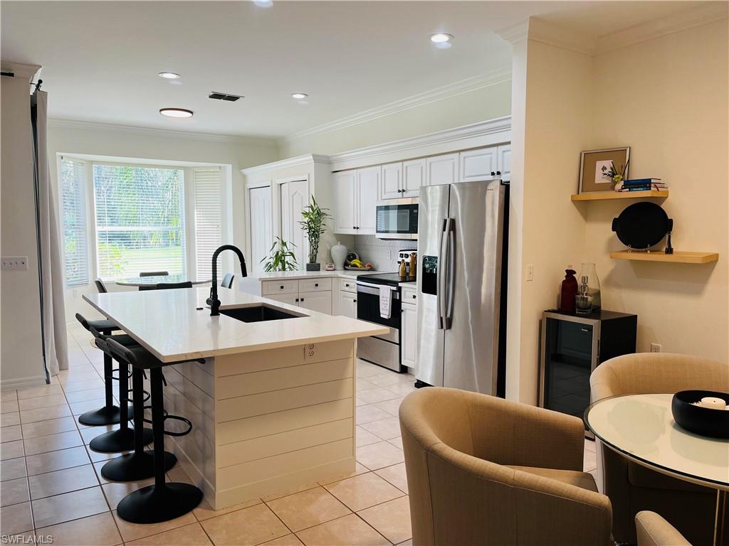 a kitchen with stainless steel appliances a sink a table and chairs