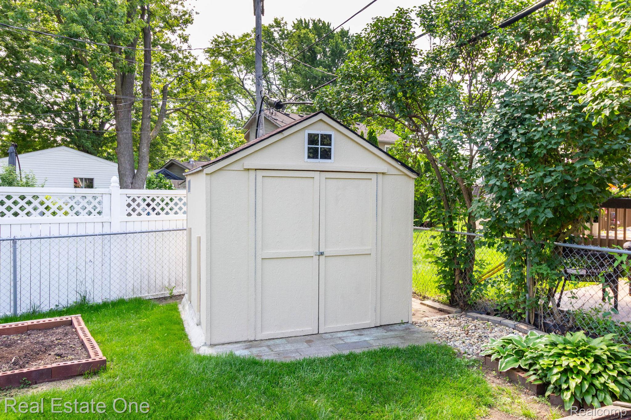 13912 Clinton River Road Sterling Heights, MI 48313 - Photo 31 of 43 Gable-roofed storage shed with a window, positioned on a paver base