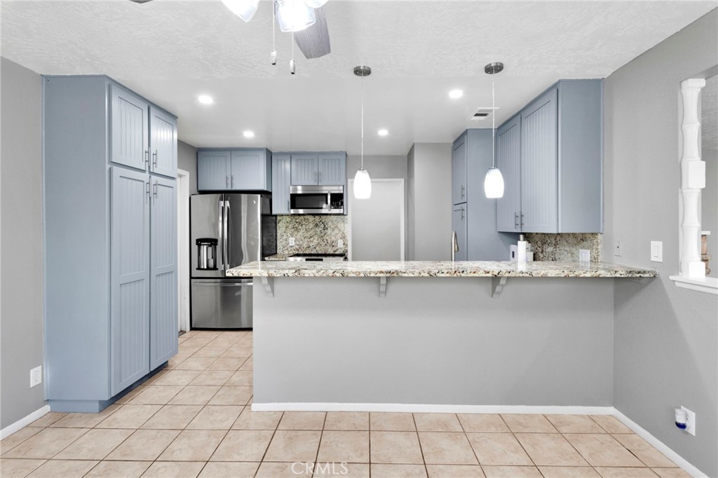 15846 Inyo Street Victorville, CA 92395 - Photo 11 of 44 a kitchen with kitchen island a counter top space a sink stainless steel appliances and cabinets