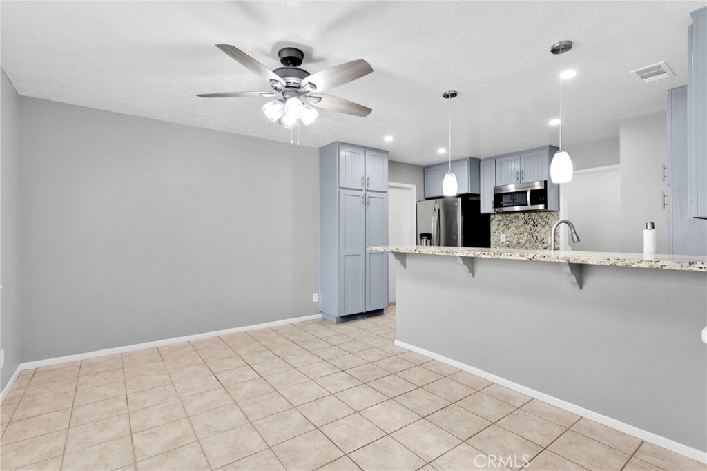 15846 Inyo Street Victorville, CA 92395 - Photo 13 of 44 a view of an empty room with kitchen and chandelier
