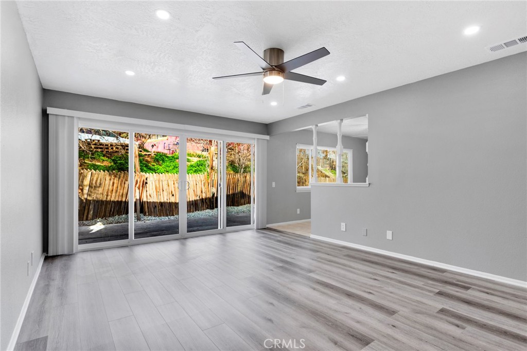 15846 Inyo Street Victorville, CA 92395 - Photo 4 of 44 an empty room with wooden floor and windows
