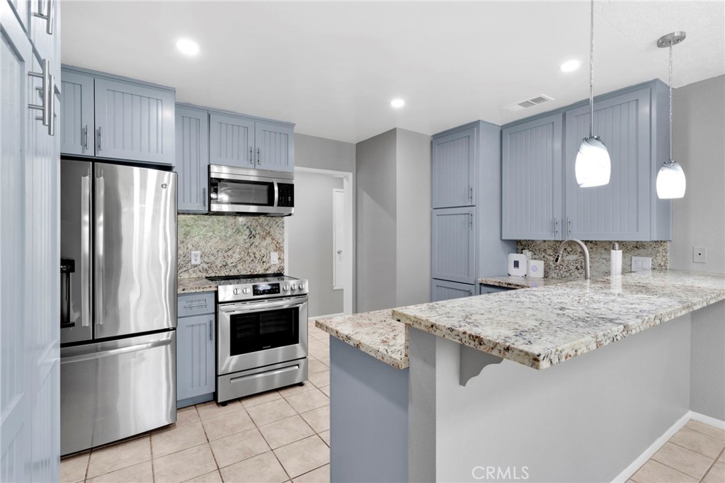 15846 Inyo Street Victorville, CA 92395 - Photo 9 of 44 a kitchen with kitchen island a sink stainless steel appliances and cabinets