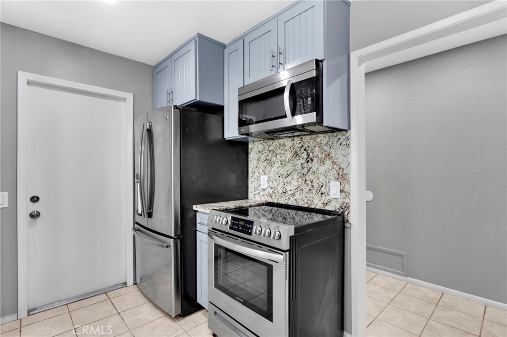 15846 Inyo Street Victorville, CA 92395 - Photo 10 of 44 a kitchen with stainless steel appliances granite countertop white cabinets a refrigerator and a stove