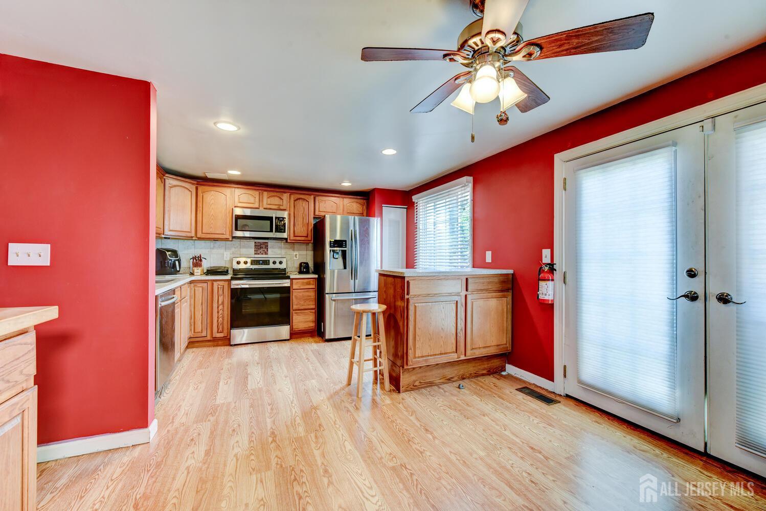 675 Bound Brook Road, Unit C0016 Dunellen, NJ 08812 - Photo 15 of 39 a kitchen with stainless steel appliances a stove top oven a sink dishwasher and a refrigerator with wooden floor
