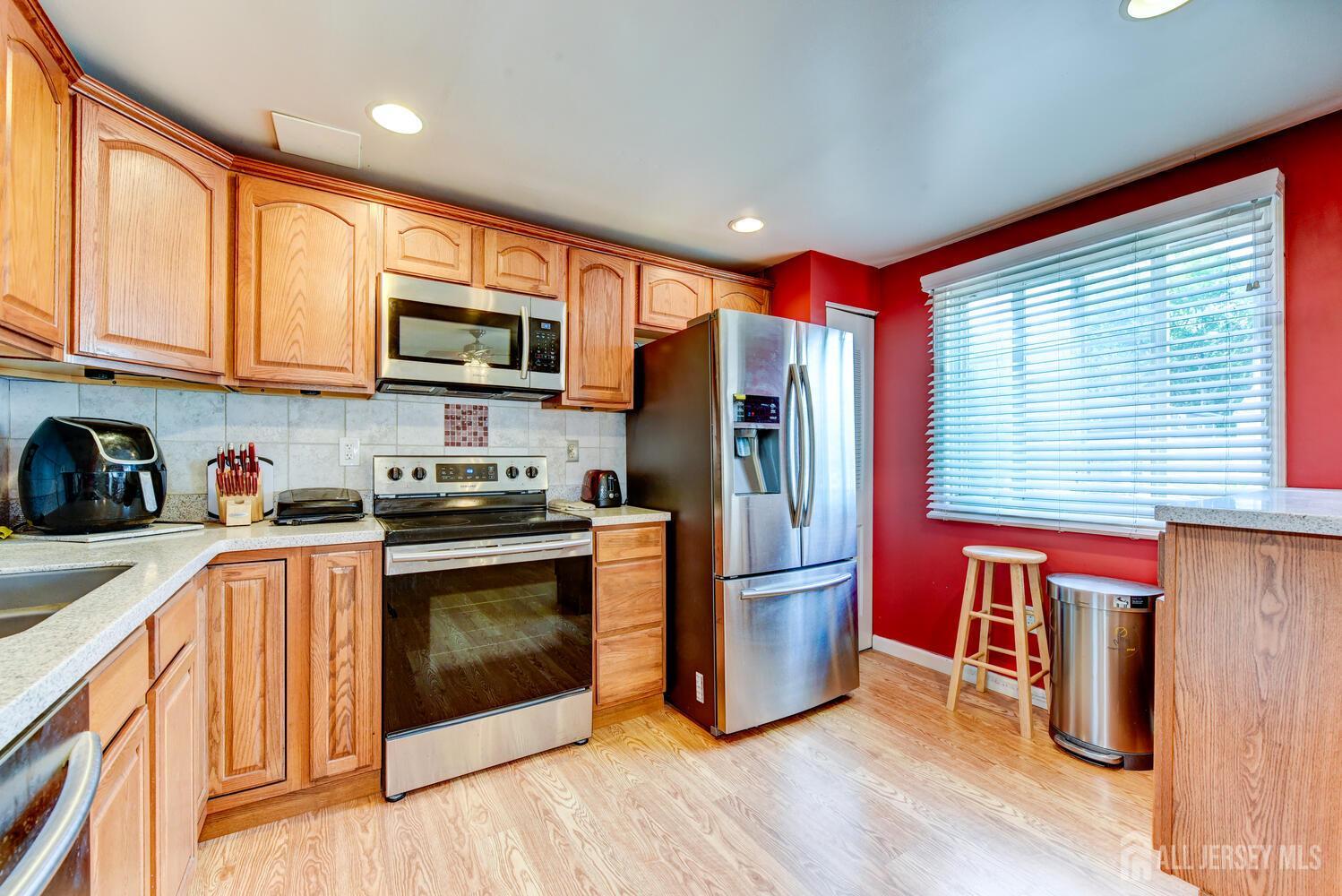 675 Bound Brook Road, Unit C0016 Dunellen, NJ 08812 - Photo 23 of 39 a kitchen with stainless steel appliances granite countertop a refrigerator and a stove top oven