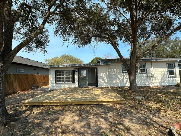 a view of a house with a tree in front