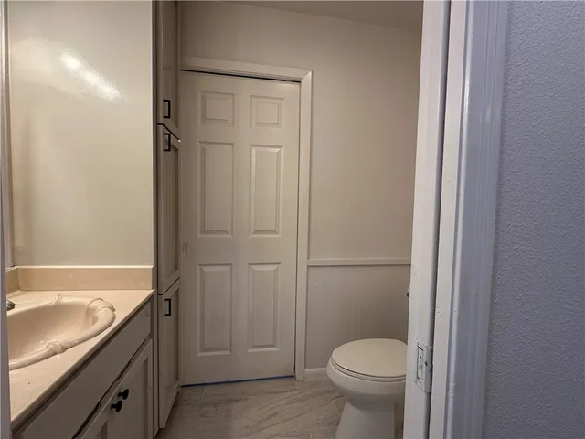 a bathroom with a granite countertop toilet a sink and bathtub