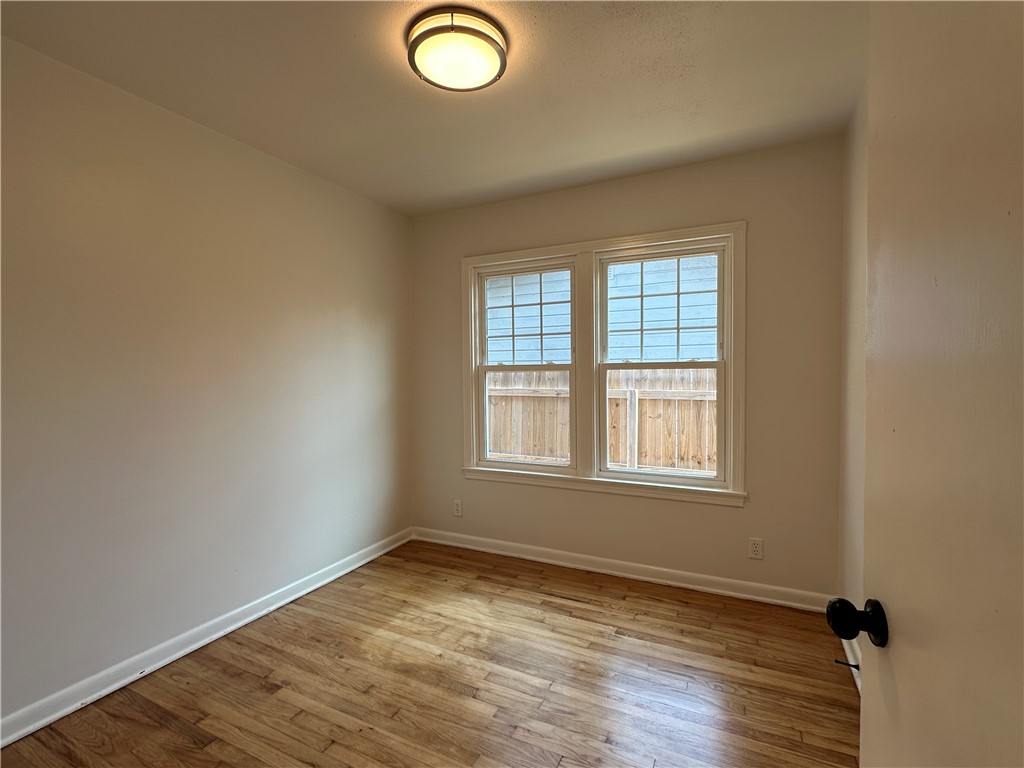 4037 Barnes Street Corpus Christi, TX 78411 - Photo 9 of 11 an empty room with wooden floor and windows