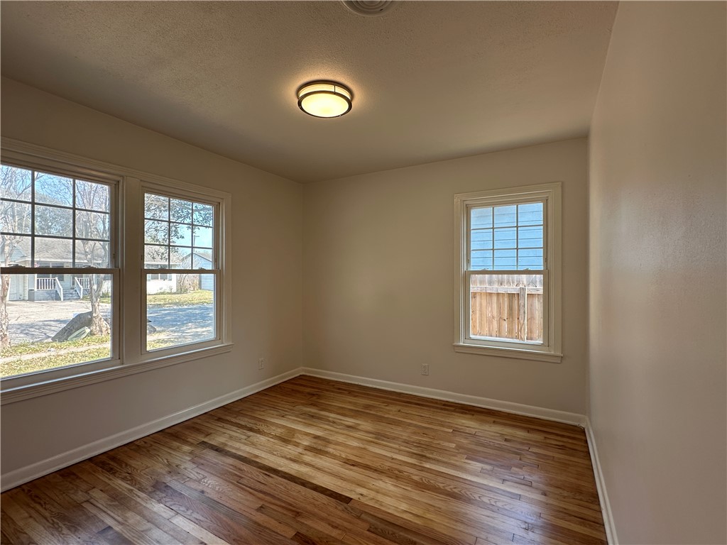 4037 Barnes Street Corpus Christi, TX 78411 - Photo 10 of 11 an empty room with wooden floor and windows