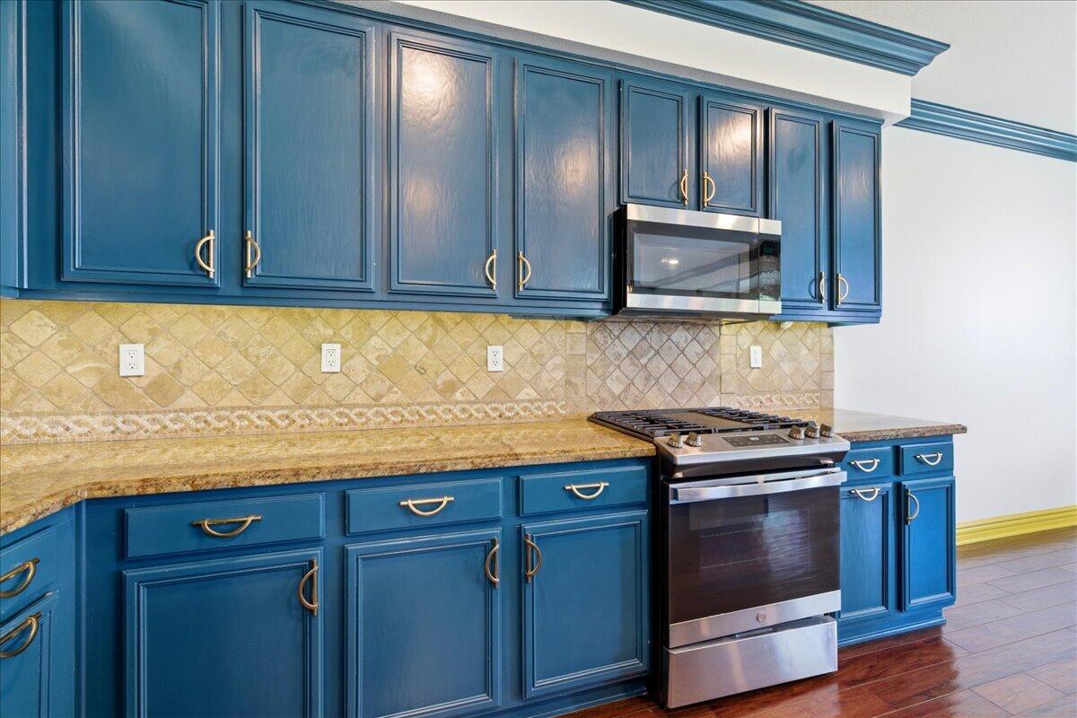 23732 Bella Vista Road Corona, CA 92883 - Photo 11 of 49 a kitchen with granite countertop cabinets stainless steel appliances and wooden floor