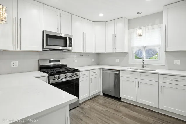 a kitchen with white cabinets and appliances