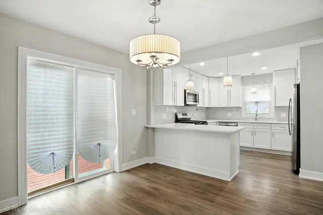 a kitchen with stainless steel appliances granite countertop a sink a refrigerator and a stove