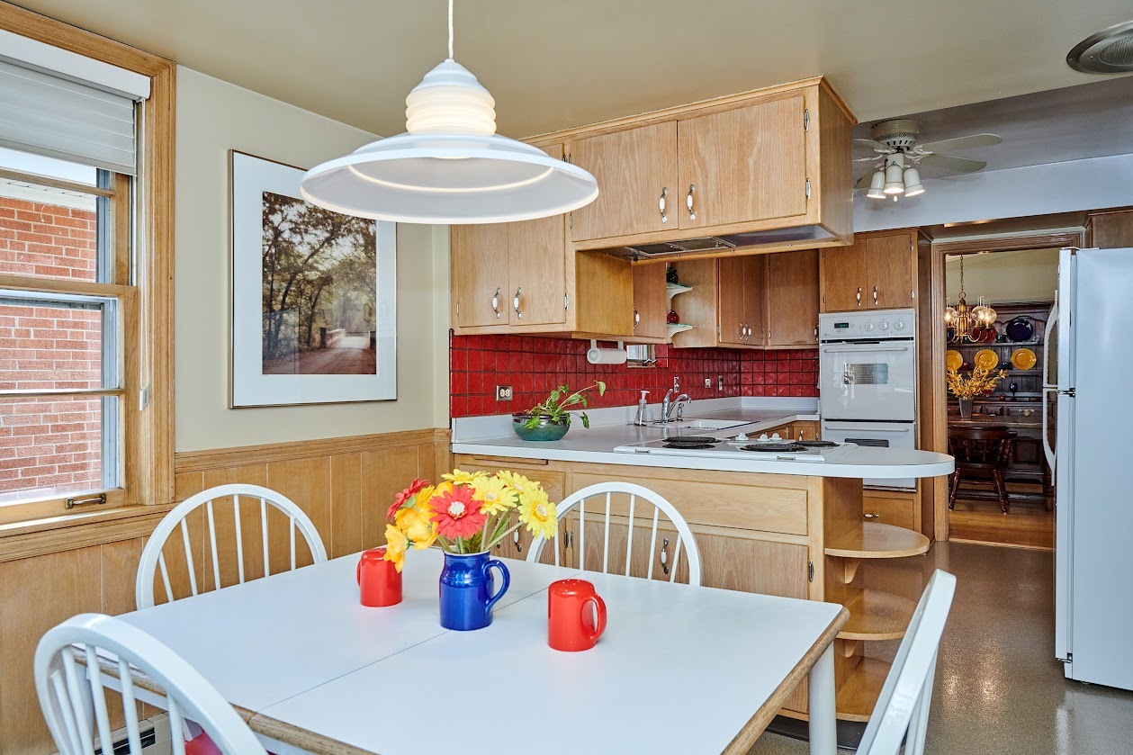 1859 Prairie Avenue Park Ridge, IL 60068 - Photo 5 of 27 a kitchen with stainless steel appliances granite countertop a dining table and chairs with wooden floor