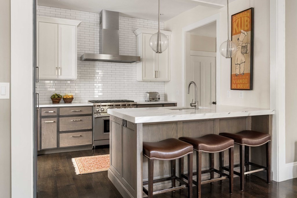 39 Meacham Road, Unit 39 Somerville, MA 02144 - Photo 12 of 40 a kitchen with a dining table chairs cabinets and stainless steel appliances