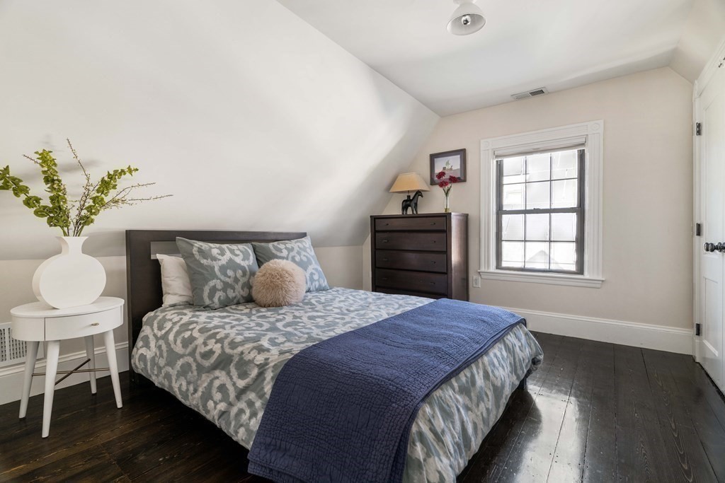 39 Meacham Road, Unit 39 Somerville, MA 02144 - Photo 30 of 40 a bedroom with a bed and wooden floor