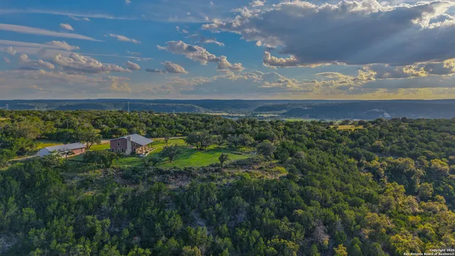 a dining room with wooden floor a chandelier a wooden table and chairs