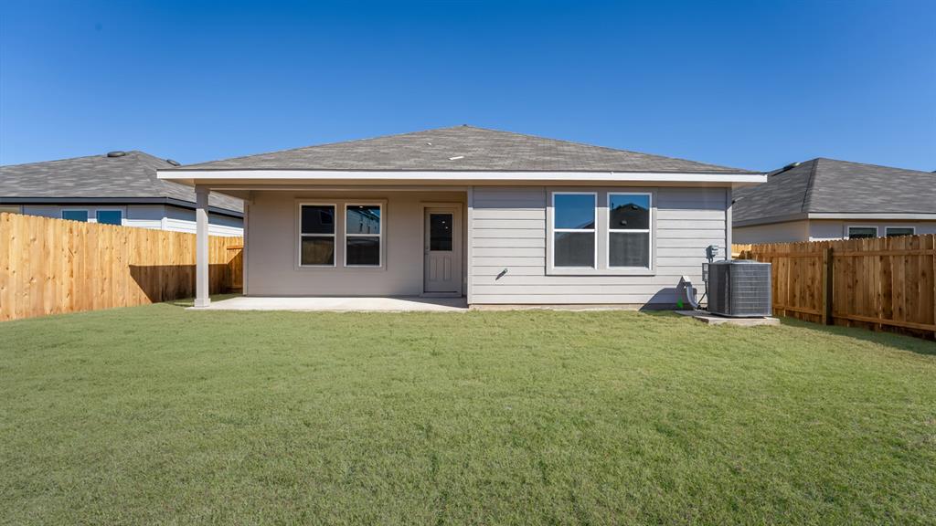 14021 Feinstein Street Manor, TX 78653 - Photo 24 of 25 A private backyard oasis with a covered patio, perfect for outdoor relaxation.