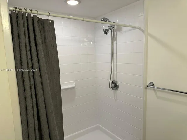 a bathroom with a shower and a glass door