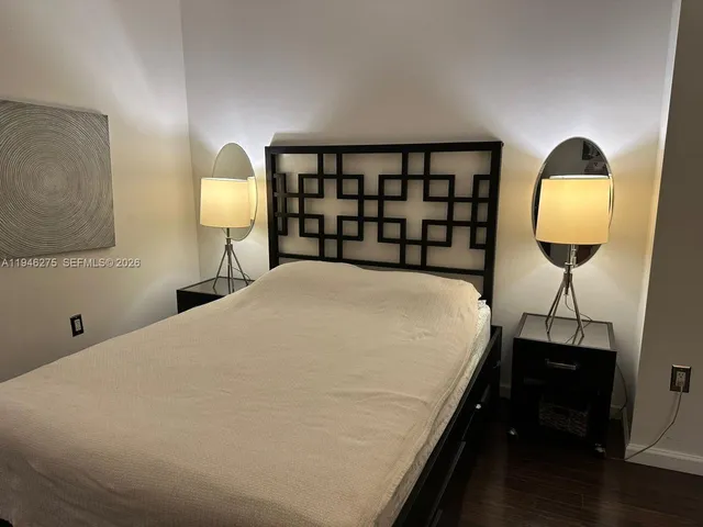 a bed sitting in a bedroom next to a lamp