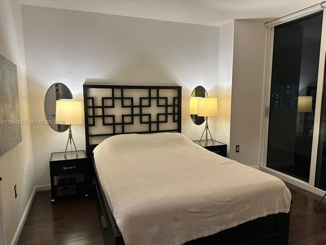 a bed sitting in a bedroom next to a lamp