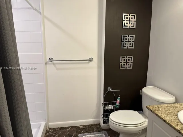 a bathroom with a toilet and a shower