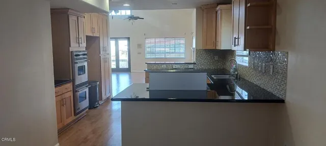 a kitchen with kitchen island a large counter top space a sink stainless steel appliances and cabinets