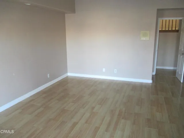 a view of an empty room with wooden floor