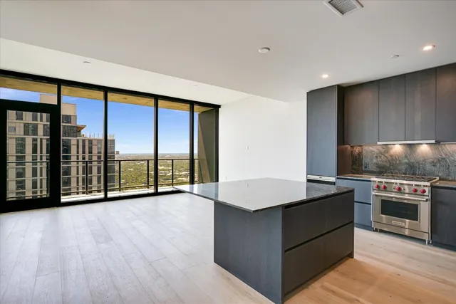 a view of kitchen with stainless steel appliances wooden floor and a large window