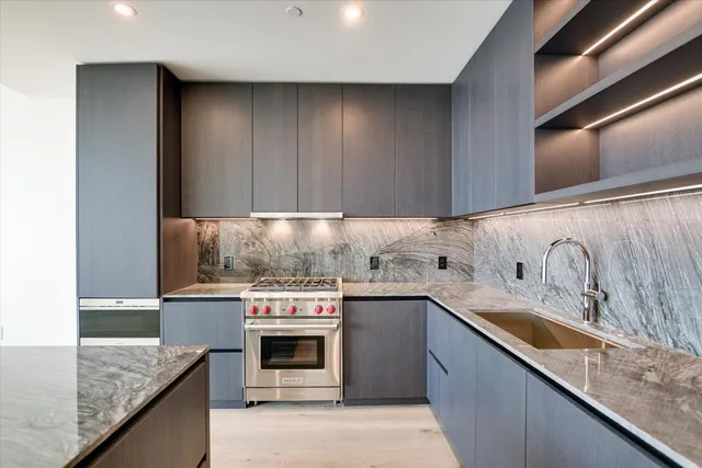 a kitchen with stainless steel appliances granite countertop a sink and a stove